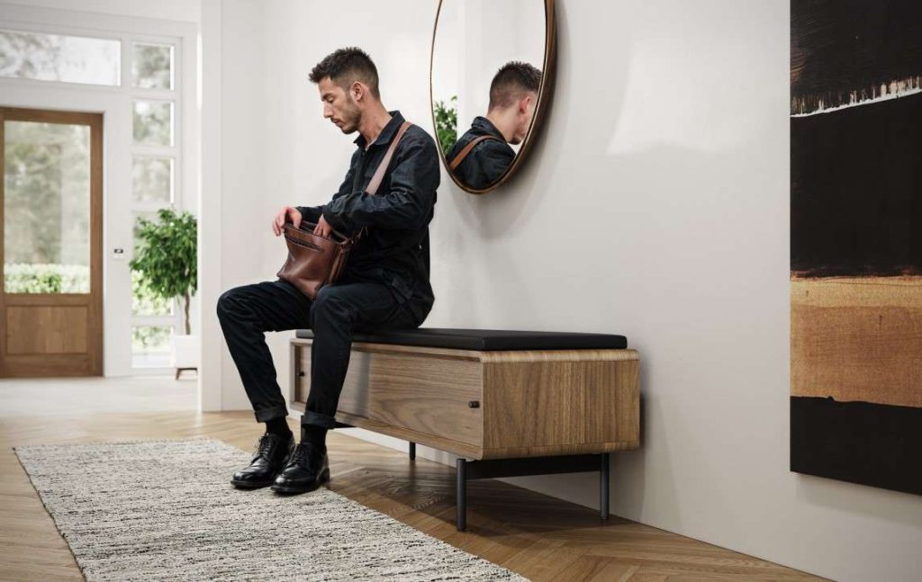 Man sitting on BDI Linq storage bench in entryway